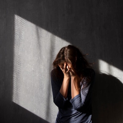 woman-standing-against-a-wall-crying-about-her-pregnancy-loss
