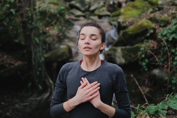 woman-standing-outside-taking-deep-breaths-in-and-out