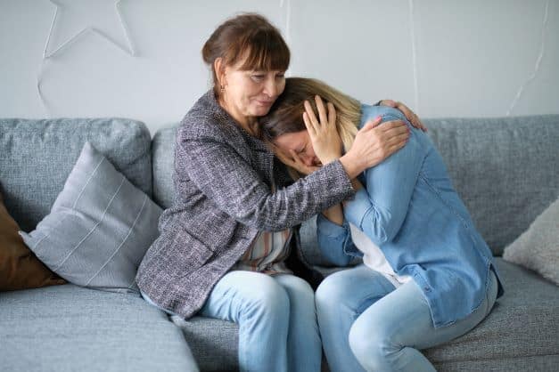 mother-getting-support-from-another-mother-shown-by-the-women-hugging