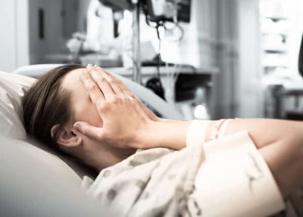 woman-laying-in-a-hospital-bed-crying-due-to-birth-trauma