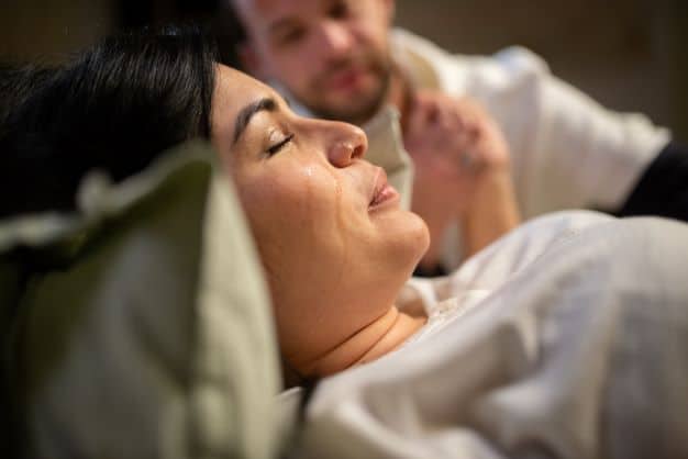 woman-crying-during-childbirth-holding-her-partner's-hand