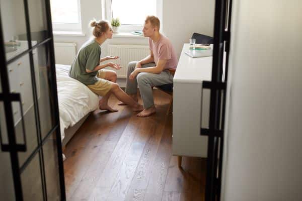 woman-talking-to-her-partner-expressing-her-feelings-sitting-in-their-bedroom