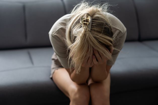 woman-sitting-on-the-couch-crying-due-to-her-grief