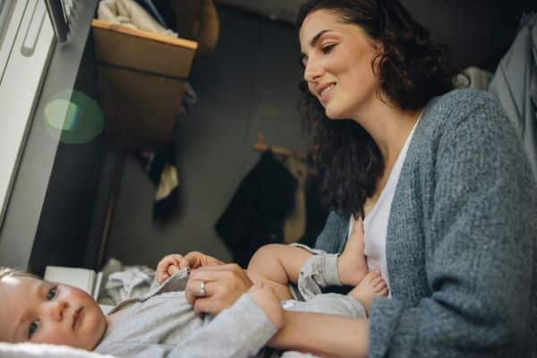 mother-changing-her-baby-on-a-changing-table-managing-her-new-routine