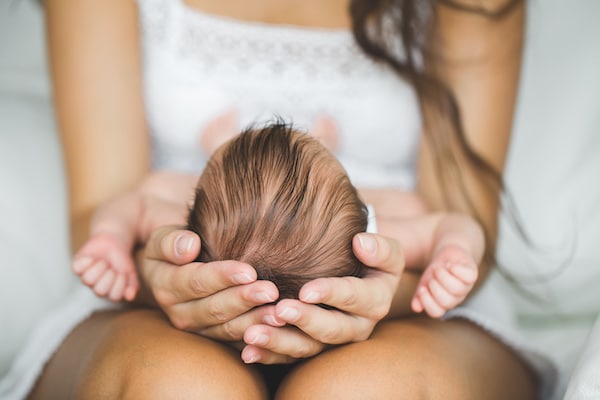 woman-cradling-the-baby-in-her-arms-on-her-lap