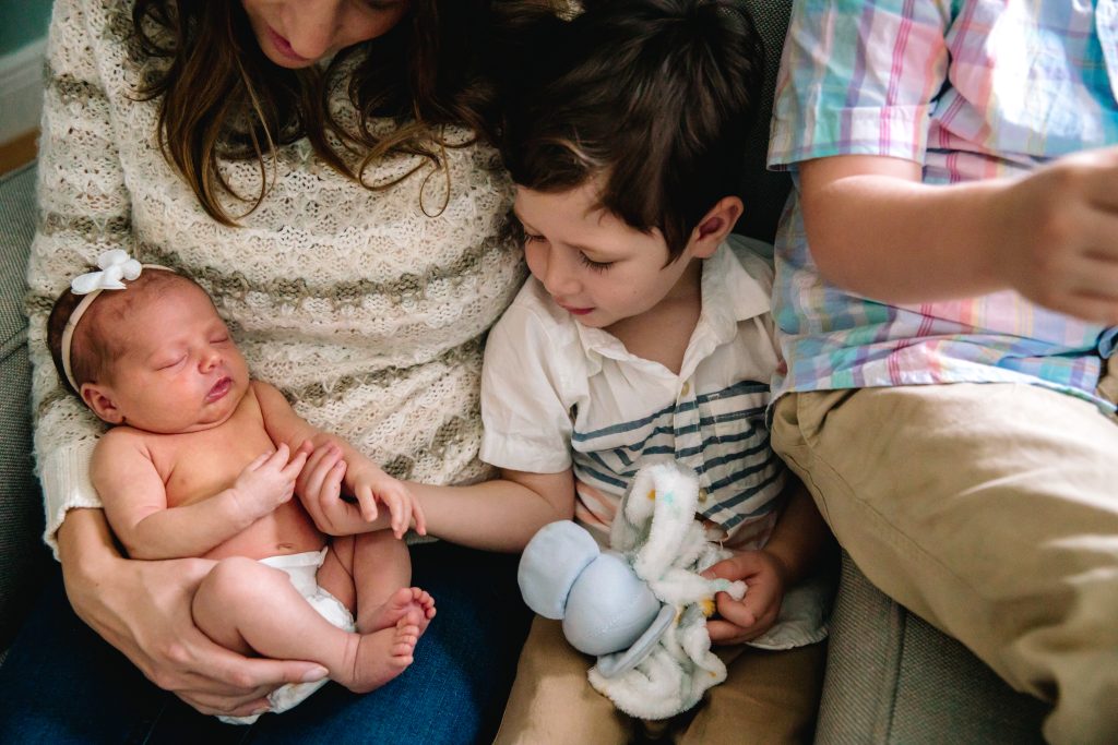 woman-reading-books-with-her-two-sons-her-infant-son-sitting-on-her-lap